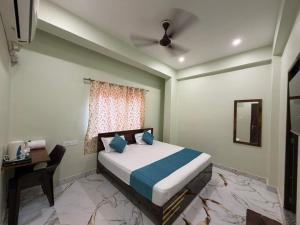 a bedroom with a bed and a desk and a window at Jogi Lodge in Varanasi