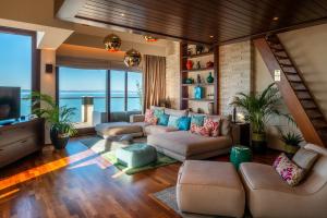 a living room with a couch and a tv at Mala Garden Design Hotel in Siófok