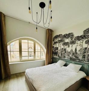 a bedroom with a bed and a large window at La Scène Audomaroise - Appartement hyper centre in Saint-Omer