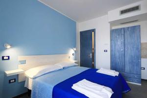 a blue bedroom with a bed with a blue blanket at Maresidence Rooms & Breakfast in Torre Pali +7 photos