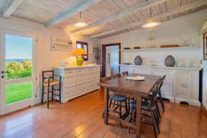 a dining room with a wooden table and chairs at Porto Ercole Prestige Villa in Cala Galera