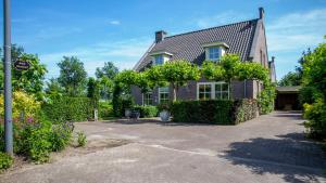 a brick house with a driveway in front of it at Bed & Breakfast Maryland in Asten-Heusden