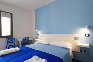 a bedroom with a bed and two blue chairs at Maresidence Rooms & Breakfast in Torre Pali