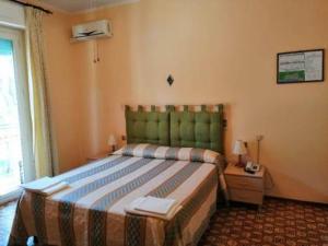 a hotel room with a bed and a window at Albergo Tre Stelle in Marina di Grosseto
