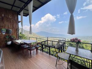 a balcony with tables and chairs and a view at ม่อนสาเคียงดาว in Ban Thung Phan Ha