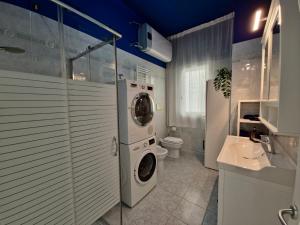 a bathroom with a washing machine and a toilet at ViaGiotto Guest House in Certaldo