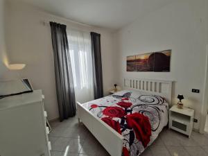 a bedroom with a bed with red roses on it at ViaGiotto Guest House in Certaldo