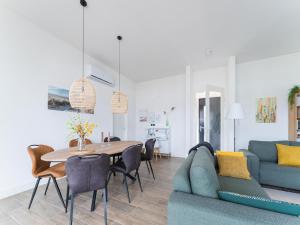 a living room with a blue couch and a table at Harderwold Villa - 384 in Zeewolde +17 photos
