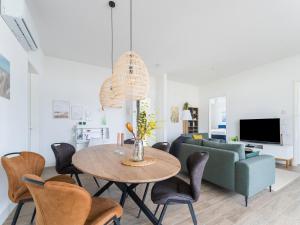 a living room with a table and a couch at Harderwold Villa - 384 in Zeewolde