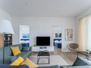 a living room with a couch and a tv at Harderwold Villa - 384 in Zeewolde