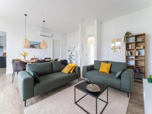a living room with two green couches and a table at Harderwold Villa - 384 in Zeewolde