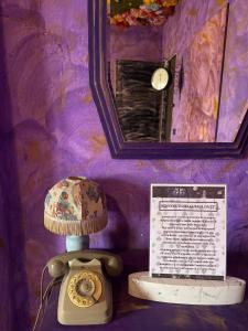 Eine Lampe mit einem Hut auf einer Wand in der Unterkunft Paciu Maison - Dimora Artistica Immersiva in Ozzano dell’Emilia
