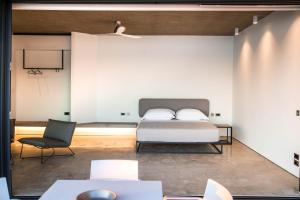 a bedroom with a bed and a chair at Echoes Milos in Kástron
