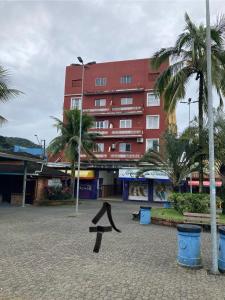 a large red building with a sign in front of it at Kitnet Cantinho 26 in Mongaguá