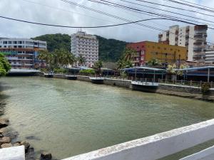 a river in the middle of a city with buildings at Kitnet Cantinho 26 in Mongaguá