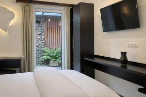 a hotel room with a bed and a television at S'Matt Bob in Feldkirch