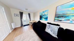 a living room with a couch and a table at Baileys Beach House - Part of the The Bay Filey Holiday Village with pool, gym and direct beach access, pub, restaurant, tennis and meadows walks in Filey