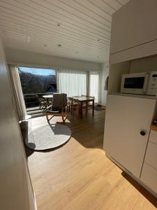 a kitchen and living room with a table and a microwave at Coquelicot in Waulsort