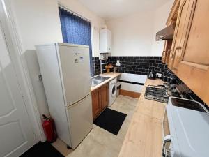 a kitchen with a white refrigerator and a sink at Cozy corner - 3 Bedroom Full House - Perfect for Families, Couples And Company Contractors in Wakefield