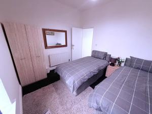 a bedroom with two beds and a mirror at Cozy corner - 3 Bedroom Full House - Perfect for Families, Couples And Company Contractors in Wakefield