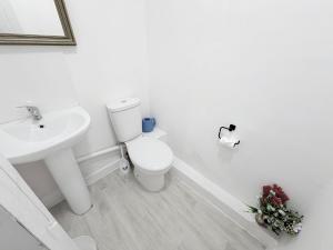 a white bathroom with a toilet and a sink at Cozy corner - 3 Bedroom Full House - Perfect for Families, Couples And Company Contractors in Wakefield