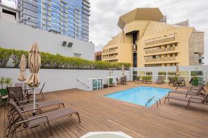a patio with chairs and a swimming pool on a building at SEQ - Sequoia Alphaville By Anora Spaces in Barueri