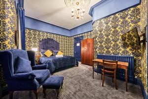 a bedroom with blue walls and a bed and a chair at Jazz House in Derry Londonderry