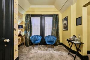 two blue chairs in a room with a window at Jazz House in Derry Londonderry +80 photos
