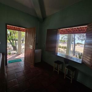 a room with a door and two windows and a porch at Pousada Mae Natureza Icapuí in Icapuí