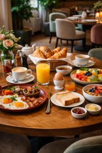 a wooden table with breakfast foods on it at Hotel YO94 in Indore
