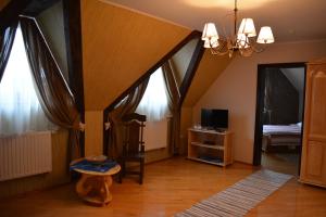 a living room with a chandelier and a room at Hotel Svitlytsia in Tyachiv