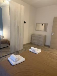 two towels sitting on a bed in a bedroom at Pella House in Airasca