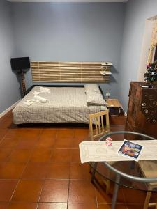 a small bedroom with a bed and a glass table at COZY Place 26 con PARCHEGGIO PRIVATO GRATUITO in Vercelli