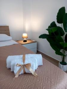 a bedroom with a bed with a white blanket and a plant at Blossom House in Isola delle Femmine +6 photos
