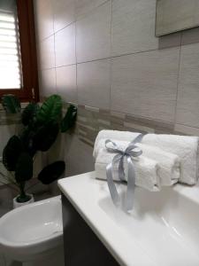 a bathroom with towels with a bow on a sink at Blossom House in Isola delle Femmine