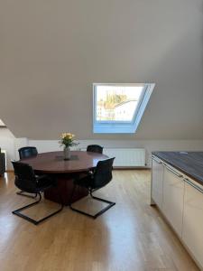 a room with a table with chairs and a window at Helle Dachgeschoßwohnung am Laurentiusplatz in Wuppertal