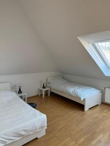 a bedroom with two beds and a window at Helle Dachgeschoßwohnung am Laurentiusplatz in Wuppertal