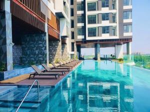 a hotel swimming pool with lounge chairs next to a building at Youyi Home in Thuan An