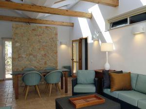 a living room with a couch and chairs and a table at Quinta das Eirinhas-Jardim de Bonsai in Tavira