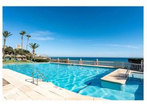a swimming pool with the ocean in the background at Urb. Lubina Sol in Mijas Costa