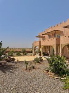 a large building in the middle of a desert at Riad Nohad Marrakech Villa Privatisée in Oulad Boudene