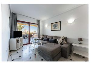 a living room with a couch and a tv at Urb. Lubina Sol in Mijas Costa