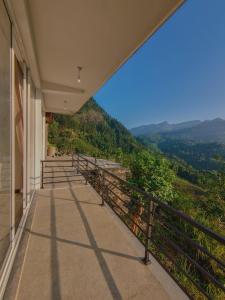 a building with a balcony with a view of a mountain at RT Point Gombamiya Hotel Kandy in Huluganga