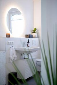 a white bathroom with a sink and a mirror at PuraStays - studio 2 in Herzogenaurach +19 photos