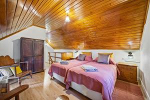 a bedroom with a large bed with a wooden ceiling at Valle Paraizo in Camacha