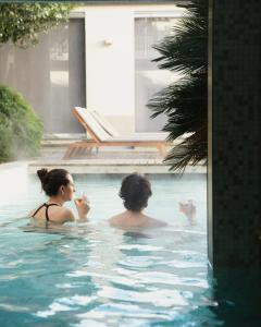 two people sitting in a swimming pool at Palazzo Castri 1874 Spa & Garden in Florence