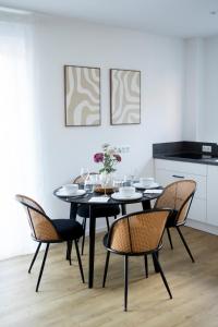 a dining room with a black table and chairs at PuraStays - studio 2 in Herzogenaurach