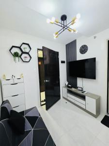 a living room with a television and a black refrigerator at 2BR Staycation in Deca Banilad by XTine City Scape in Banilad