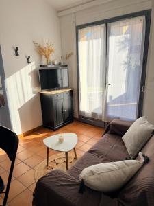 a living room with a couch and a table at Mazet avec piscine collective in Le Lavandou