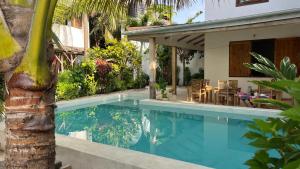 a swimming pool next to a house with a palm tree at Nakupenda paje villa in Paje
